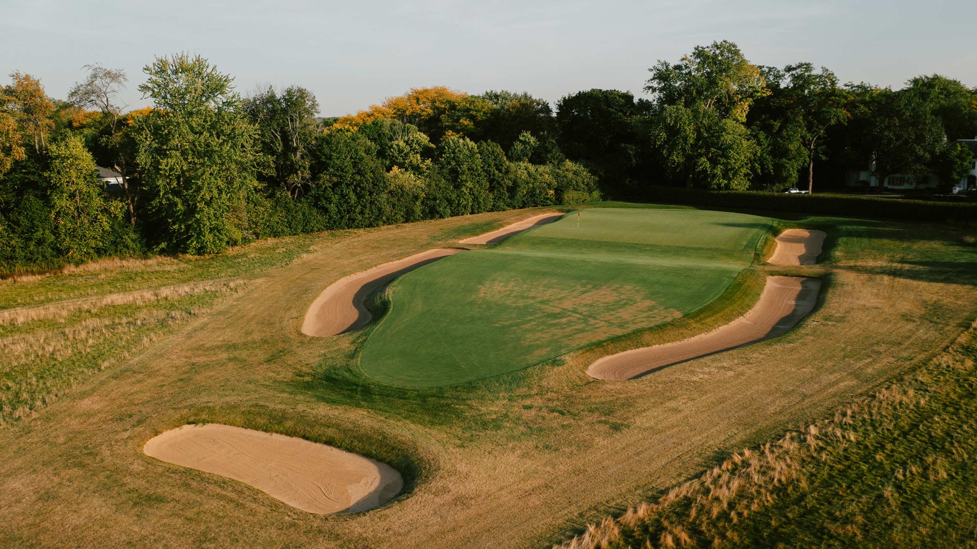 A Biarritz template green — long, narrow, flanked by sand, with a clear central swale running across it.